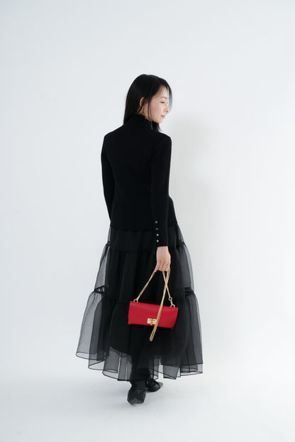 e-clothing-online storeのCLOCHE黒リブハイネックニット。袖口のゴールドボタンが特徴で、チュールスカートと赤いバッグを合わせたエレガントな着こなし。