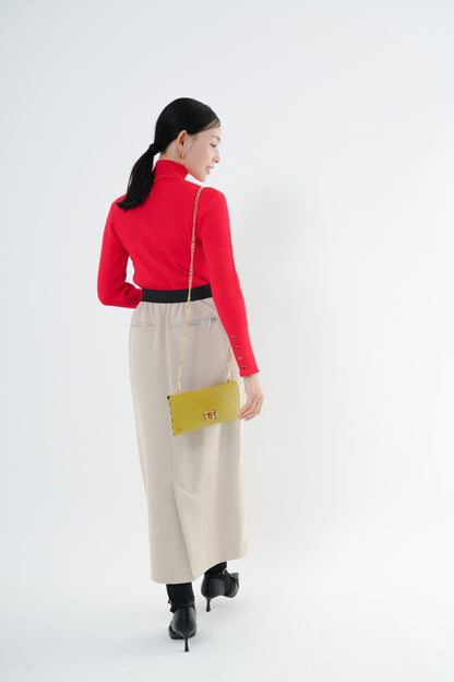 e-clothing-online storeのCLOCHEリブハイネックニットを着用した女性。袖口のゴールドボタンが特徴的な赤色のリブニット。