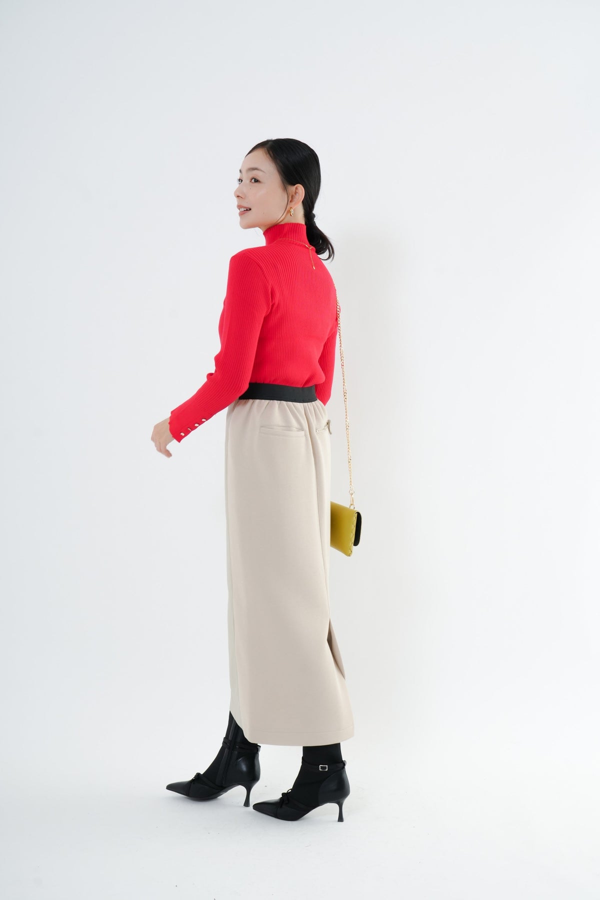 e-clothing-online storeのCLOCHEリブハイネックニット。袖口のゴールドボタンが特徴的な赤のリブニットをベージュのロングスカートに合わせた秋冬のきれいめコーデ。