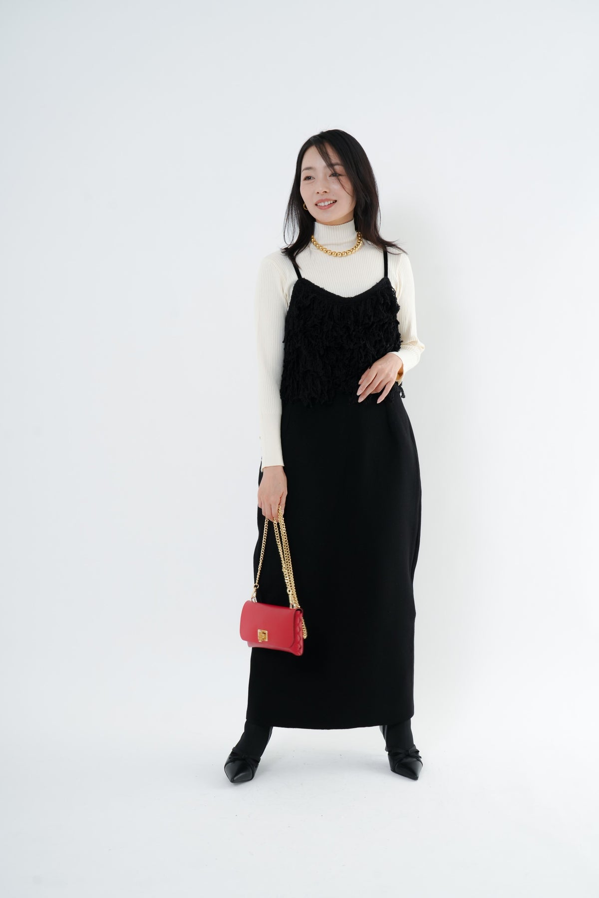 e-clothing-online storeのCLOCHEリブハイネックニットを着用し、黒のキャミワンピースと赤いバッグを合わせた女性