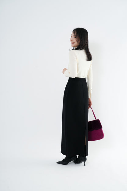 e-clothing-online storeのCLOCHEリブハイネックニットを着用した女性。ホワイトのタートルネックにブラックのロングスカートを合わせたきれいめなコーディネート。