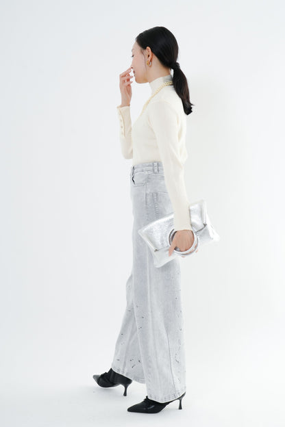e-clothing-online storeのCLOCHEリブハイネックニットを着用した女性。袖口のゴールドボタンが特徴のホワイトニットに、ライトグレーのデニムとシルバーのバッグを合わせたきれいめコーデ
